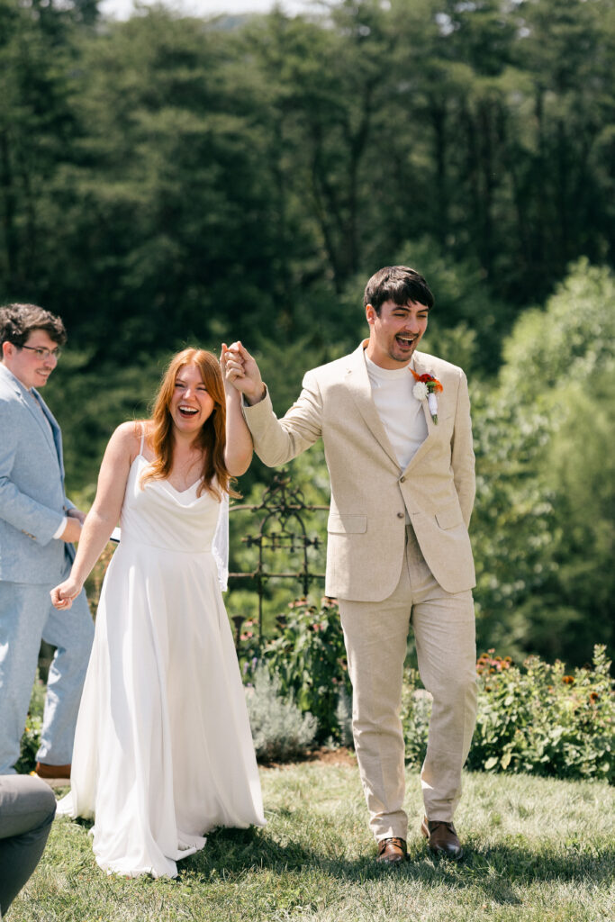 bride and groom smiling and walking down aisle