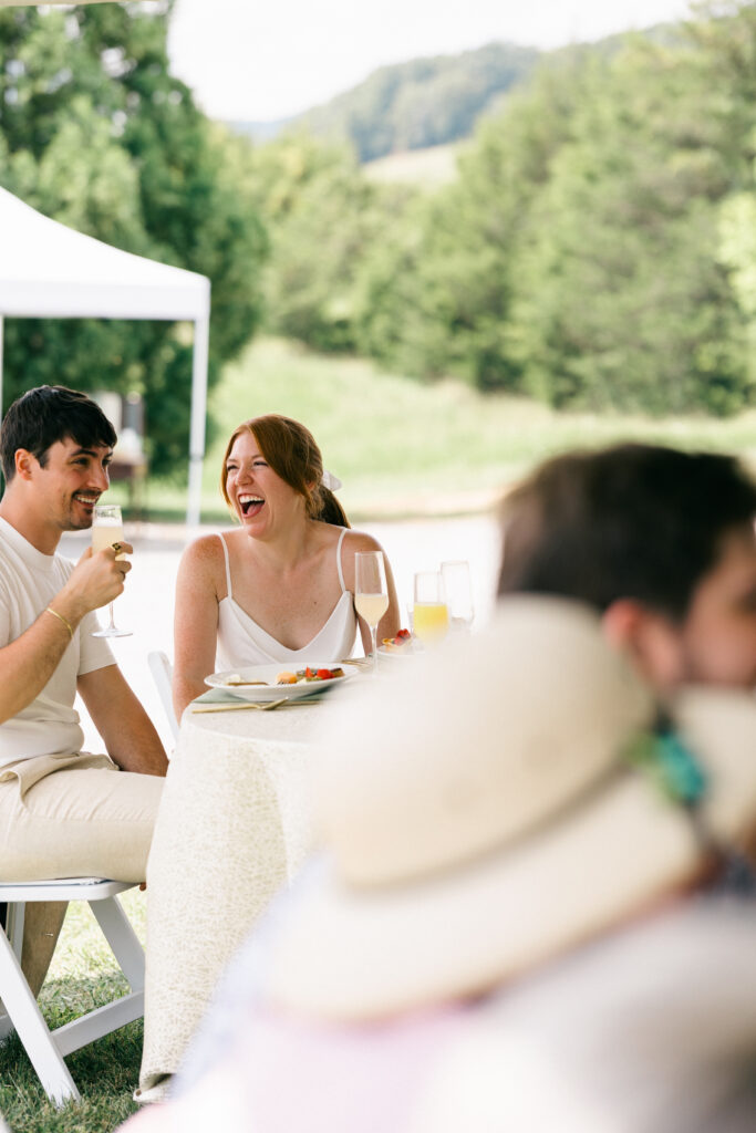 bride and groom laughing while toasts are taking place
